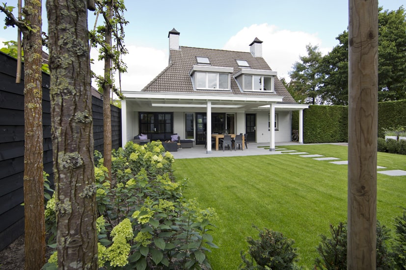 Witte veranda uitgevoerd met sierlijke klossen 7 Houten veranda vanuit de tuin